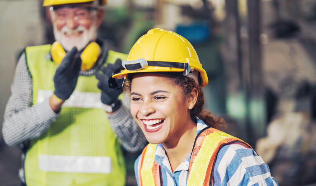 workers wearing PPE with one applauding the other