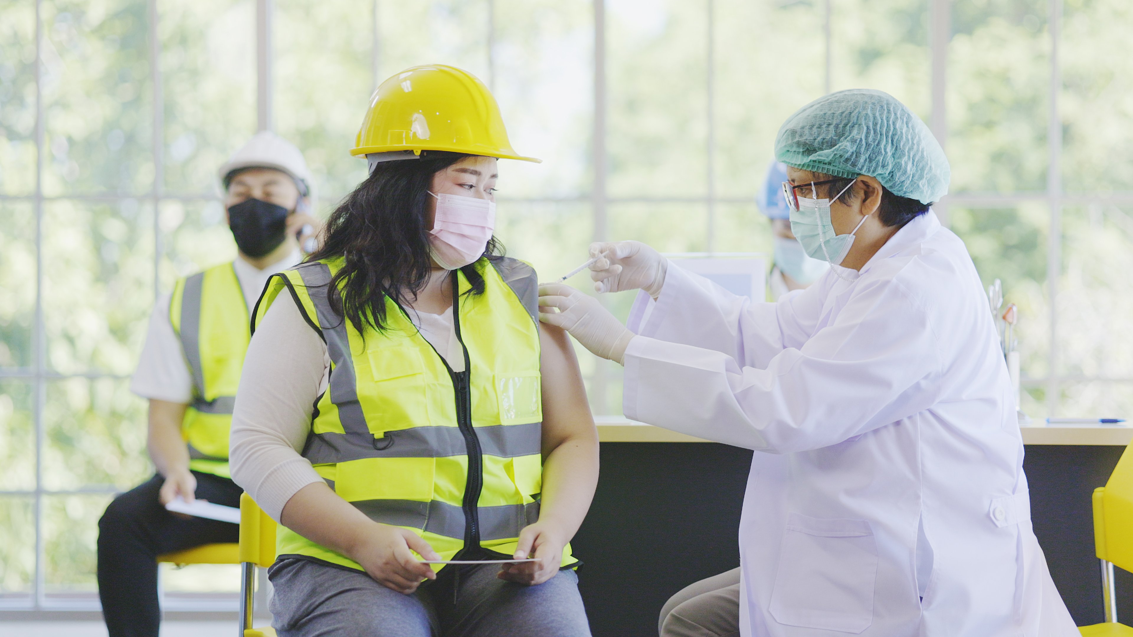 female-construction-worker-receving-injection-shutterstock_2003188112